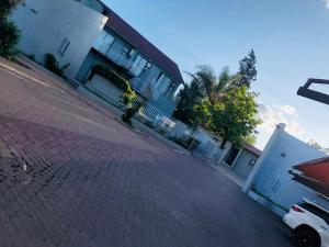 una calle con un edificio y un coche aparcado en la calle en Eeufees Guesthouse en Bloemfontein