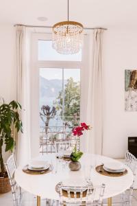 una sala da pranzo bianca con tavolo e finestra di Front Lake Pearl 5 for 6PAX -By EasyLife Swiss a Lugano