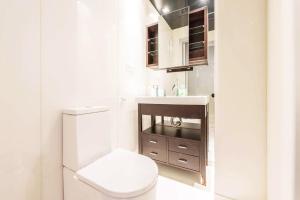 a white bathroom with a toilet and a sink at My City Home - Dúplex PH III in Madrid