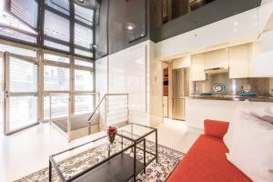 a living room with a red couch and a glass table at My City Home - Dúplex PH III in Madrid +29 photos