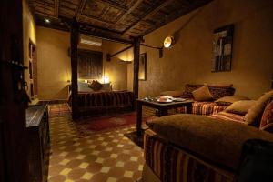 ein Wohnzimmer mit einem Sofa und einem Bett in der Unterkunft Kasbah Hotel Xaluca Arfoud in Erfoud