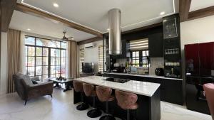 una cucina con bancone e bancone con sgabelli di KaMi Villa - Novaworld Phan Thiết a Bình Tú