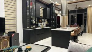 una cucina con armadi neri e un bar con tavolo di KaMi Villa - Novaworld Phan Thiết a Bình Tú Altre 95 foto