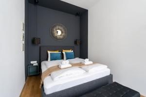 维也纳Glam 1BR Suite, Easy City Path by HM的卧室配有一张大床,墙上装有镜子