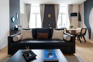 维也纳Glam 1BR Suite, Easy City Path by HM的客厅里有一张黑色沙发和一张桌子