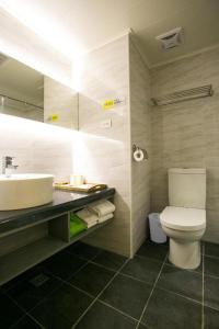 台中的住宿－台中皇星商旅上安館，浴室配有白色卫生间和盥洗盆。