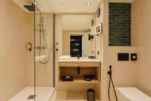 a bathroom with a sink and a shower at Golf Hôtel de Valescure & Spa NUXE in Saint-Raphaël