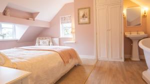 a bedroom with a bed and a sink at Wild Pear Cottage in Wolford