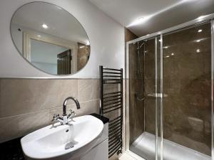 a bathroom with a sink and a shower and a mirror at 2 Shanklin Manor - Ground Floor apartment overlooking Park in Shanklin Old Village in Shanklin +43 photos