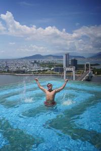 a man in a swimming pool in the water at GOLDEN APARTMENT With SEA VIEW in Da Nang