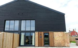 a black house with a black roof and windows at Peasgood in Spilsby