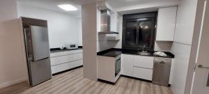 a kitchen with white cabinets and stainless steel appliances at APARTAMENTO Temple I in Ponferrada