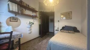 1 dormitorio con cama y lámpara de araña en Maison De Dora, en San Giuliano Terme
