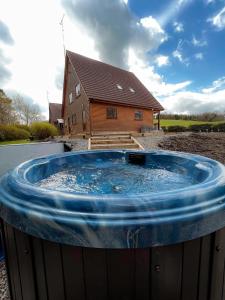 a large hot tub in front of a house at Large Newly Refurbished Lakeside Chalet With Optional Hot Tub & Boat Hire in Duneena