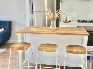 a kitchen with a wooden table with two stools at Fully Equipped 3BR-Townhouse in Northfield