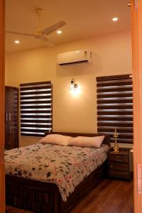 1 dormitorio con 1 cama y ventilador de techo en RIVA Marari Beach Homestay, en Mararikulam