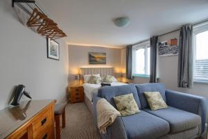 un soggiorno con divano blu e letto di Smugglers Luxury Accommodation a Sheringham