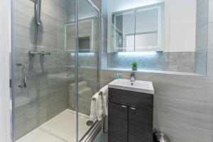 uma casa de banho com uma cabina de duche em vidro e um lavatório. em Wellington House by Celador Apartments em Reading