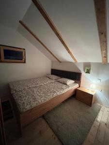 Dormitorio pequeño con cama y mesa en DRiM Wood House, en Lasinja