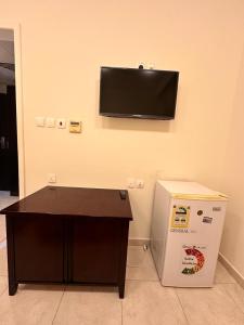 a room with a desk and a television on the wall at ALBILAD ROYA HOTEL in Makkah