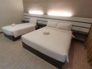 2 Betten in einem Hotelzimmer mit Handtüchern darauf in der Unterkunft Grand Kapar Hotel Kuala Selangor in Kuala Selangor