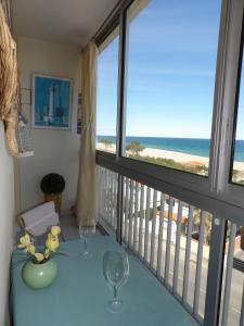 een balkon met een tafel en 2 wijnglazen bij Vue superbe sur la Belle Bleue avec 2 chambres in Saint-Cyprien