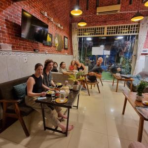 un grupo de personas sentadas en una mesa en un restaurante en STAY SWEET, en Phnom Penh