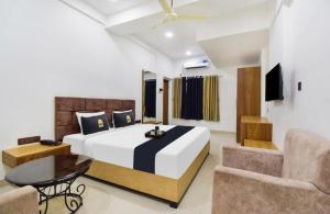 a bedroom with a bed and a table and a couch at Hotel Palace in Chandrapur