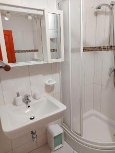een witte badkamer met een wastafel en een douche bij Apartment Ivan in Trogir