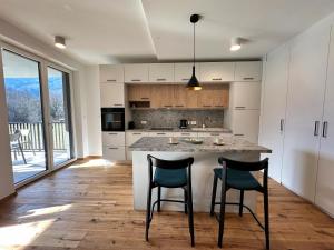 a kitchen with a large island with two chairs at Soca Valley Suites in Bovec