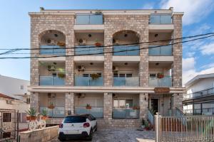 a white car parked in front of a building at Mila & Aleksandr Apartments in Budva