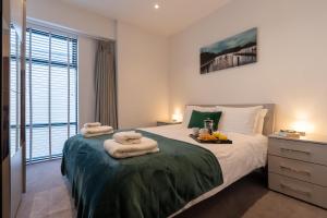 1 dormitorio con 1 cama con 2 toallas en Wellington House by Celador Apartments en Reading