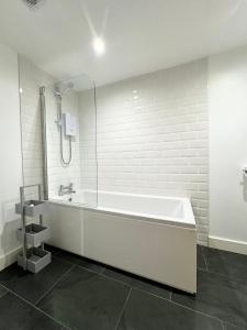 y baño blanco con bañera y ducha. en The Town House Apartments, Ulverston - Lake District en Ulverston