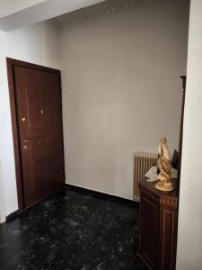Zimmer mit einer Tür und einem Tisch mit einer Statue in der Unterkunft Διαμερισμα 77τ.μ in Sparta