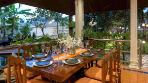 a wooden table with chairs and a tableasteryasteryasteryasteryasteryasteryasteryastery at Talay Naiharn Villa in Rawai Beach