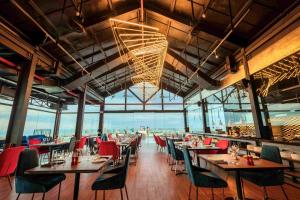un restaurante con mesas y sillas y una lámpara de araña en GOLDEN APARTMENT With SEA VIEW en Da Nang