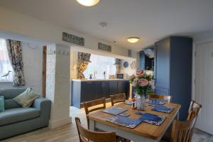 a living room with a dining table and a kitchen at Smugglers Luxury Accommodation in Sheringham