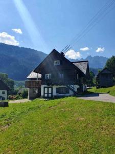 una casa sentada en la cima de un exuberante campo verde en Ferienhaus Asterbach, en Gosau