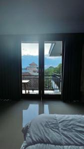 a bedroom with a bed and a view of a balcony at Tirta Kemala House in Ubud