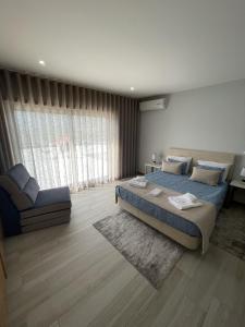 1 dormitorio con 1 cama grande y 1 silla en Douro Visit House, en Torre de Moncorvo