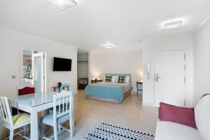 a living room with a bed and a table at Forum T0 Plus in Ilhéu do Gorgulho