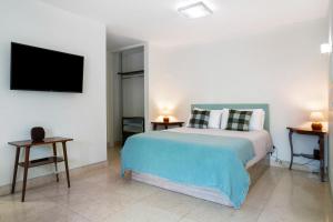 a bedroom with a bed and a flat screen tv at Forum T0 Plus in Ilhéu do Gorgulho