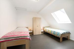a attic bedroom with two beds and a window at Christiane in Tholey