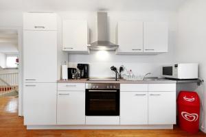 a white kitchen with white cabinets and a microwave at Christiane in Tholey