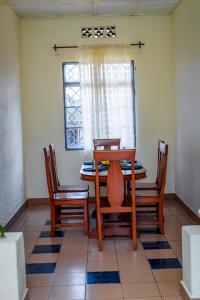 ein Esszimmer mit einem Tisch und 4 Stühlen in der Unterkunft Rhoja homes in Ruhengeri