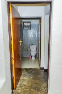 a bathroom with a toilet through a doorway at Rhoja homes in Ruhengeri