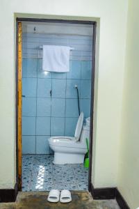 a bathroom with a toilet and a pair of slippers at Rhoja homes in Ruhengeri