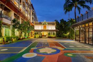 an exterior view of a building with a tile driveway at Thanthip Beach Resort Patong in Patong Beach