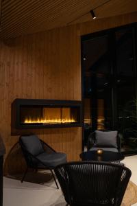 a fireplace in a room with two chairs and a table at Sorrisniva Arctic Wilderness Lodge in Alta
