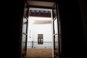 een open deur met uitzicht op een balkon bij Hostal Café FRENTEABASTOS in Carmona